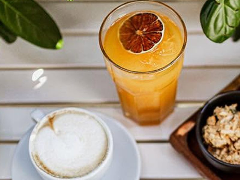 Narancslé és cappuccino a teraszasztalon